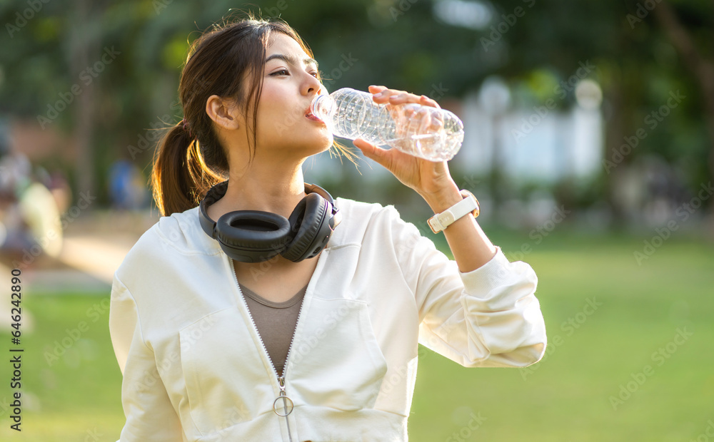 Portrait sport asian beauty body slim woman drinking water from a bottle while relax and feeling fre