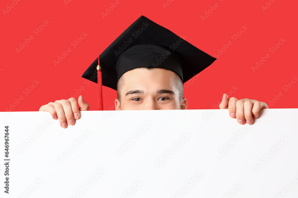 Male graduate student with blank poster on red background, closeup