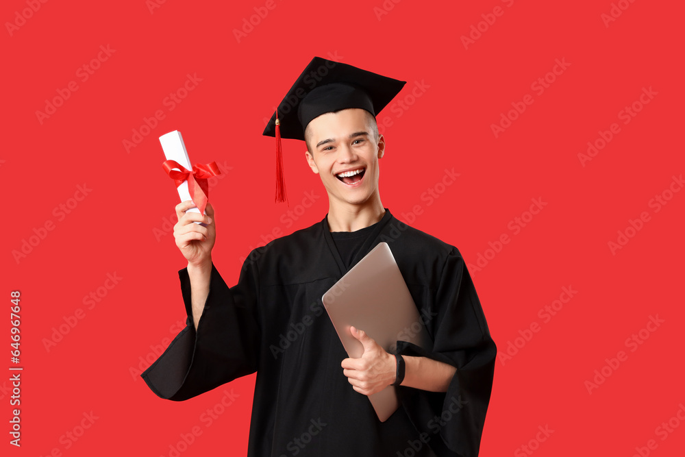 Male graduate student with diploma and laptop on red background