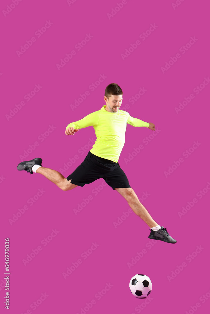 Jumping soccer player on magenta background