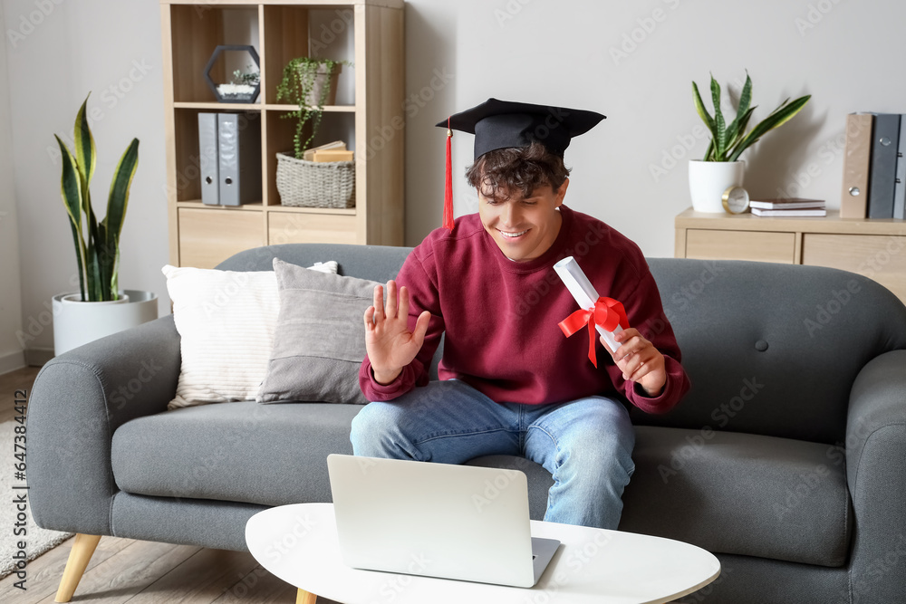 Male graduate student with diploma video chatting at home