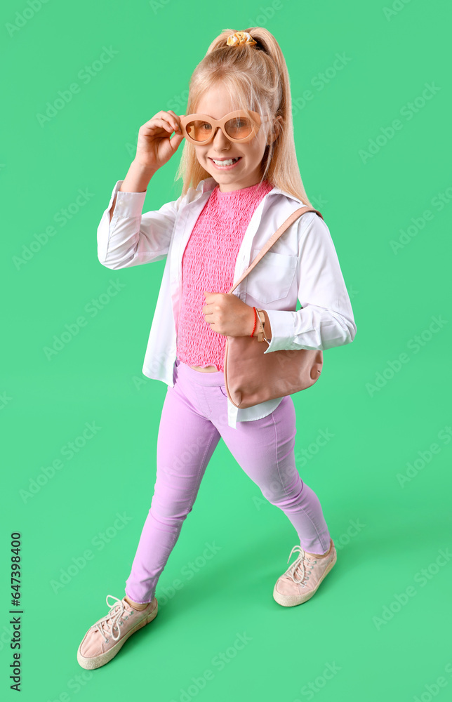 Stylish little girl on green background