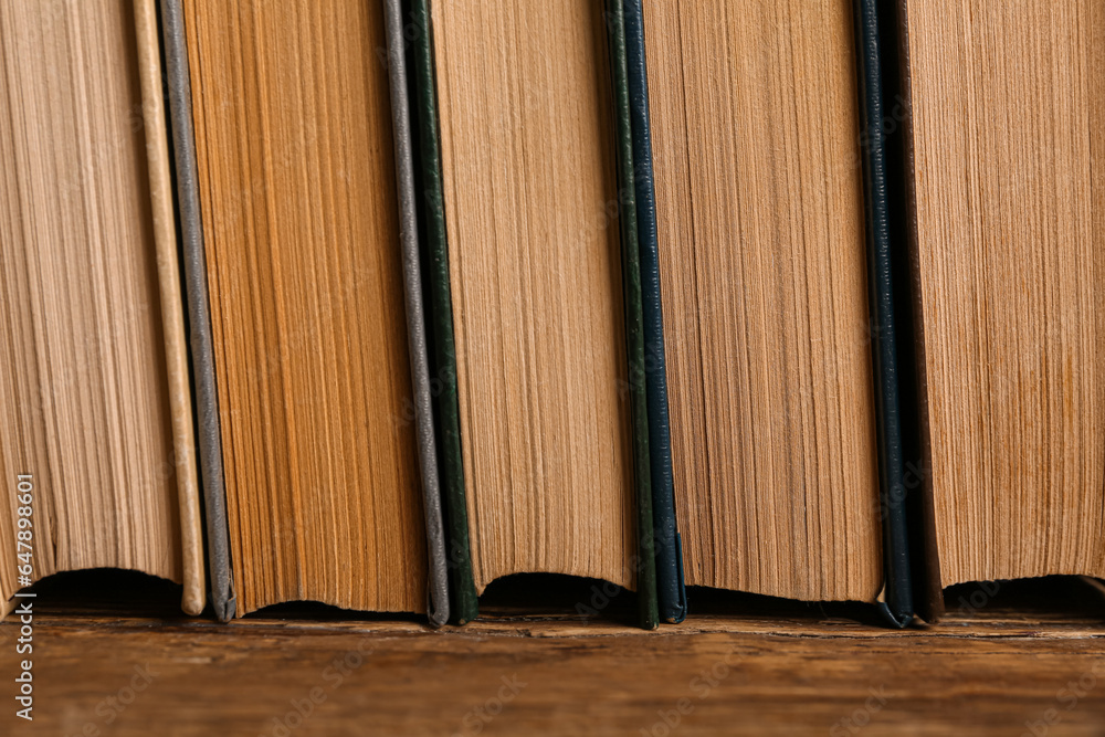 Stack of old hardcover books on wooden background, closeup