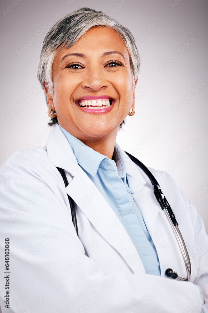 Woman, portrait and doctor smile in studio with arms crossed for consulting of healthcare services. Happy mature surgeon, expert therapist and medical professional with experience on grey background