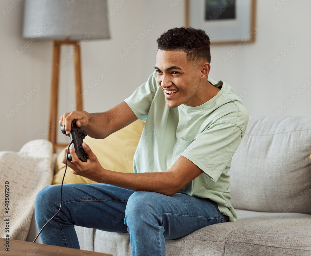 Happy man, video games and playing on sofa with controller in living room for fun online match at home. Young male person enjoying game time on console for friendly competition or esports in house