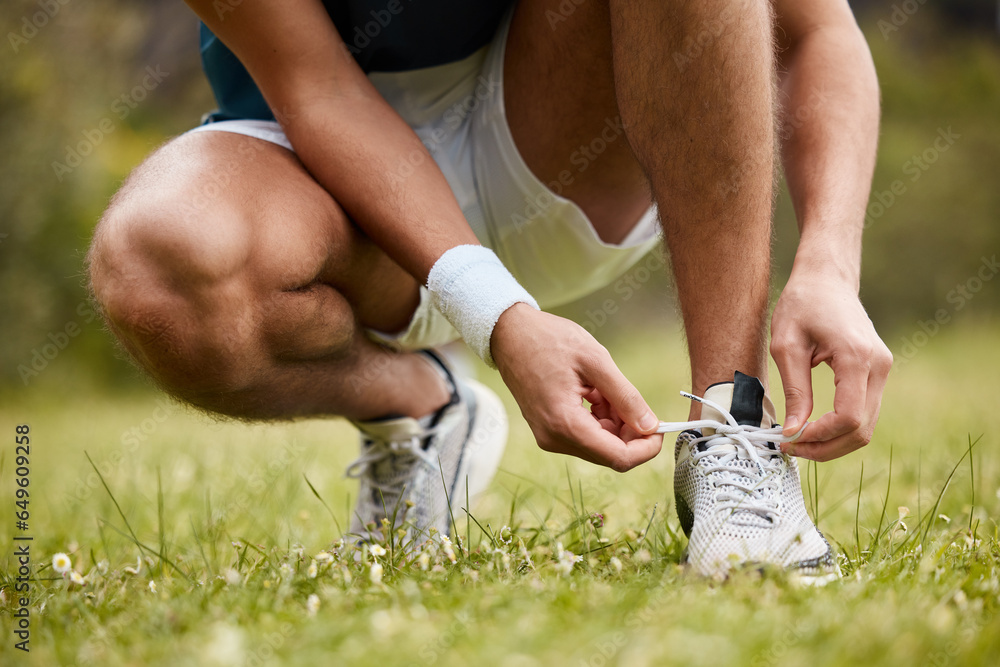 Shoes, tie and a sports person getting ready for an exercise run closeup outdoor for cardio training. Fitness, hands or feet with an athlete at the start of his marathon on a field of grass in summer