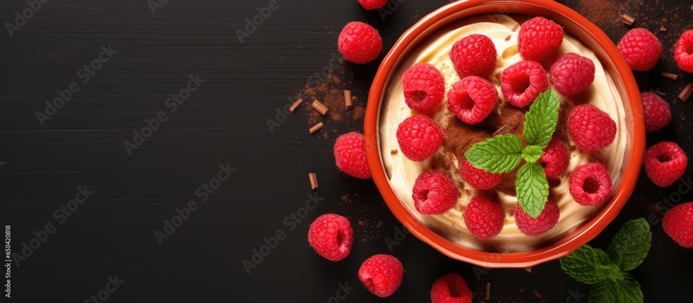 Red ceramic Tiramisu with raspberries and chocolate Traditional Italian delicacy Overhead perspective