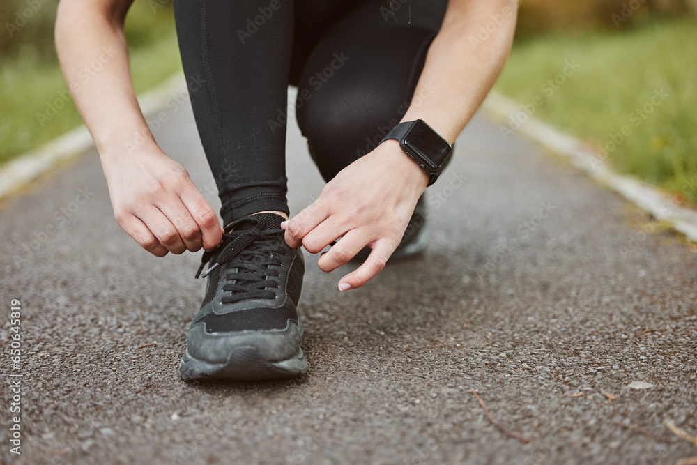 Person, hands and tying shoes in fitness getting ready running exercise or outdoor cardio workout. Closeup of athlete or runner tie shoe on asphalt in preparation for training or run at the park