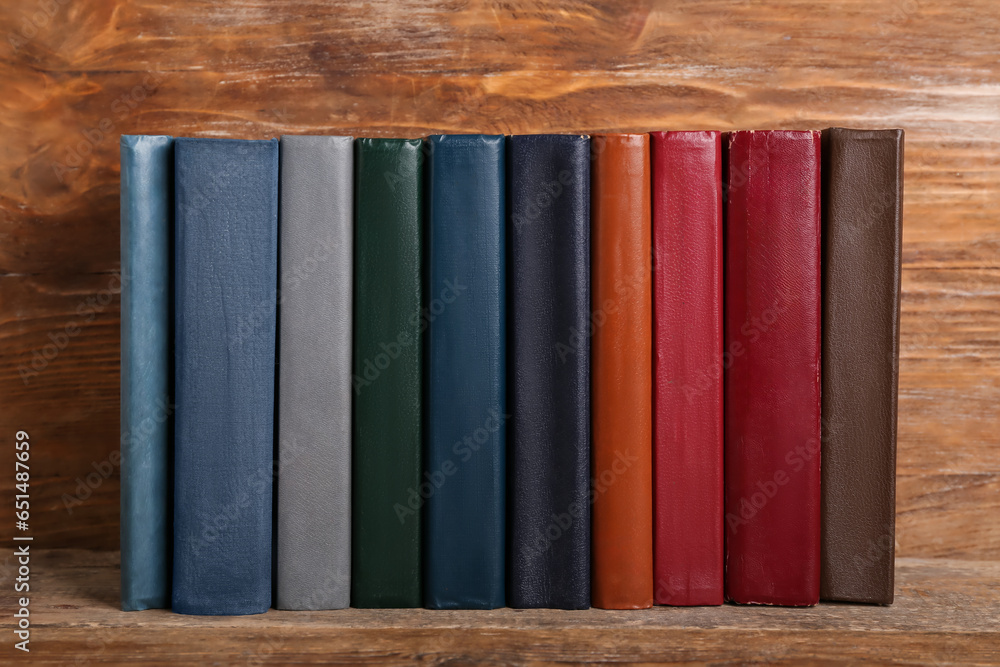 Row of old hardcover books on wooden background, closeup