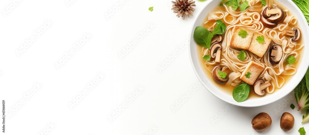 Asian vegan noodle soup with tofu cheese shiitake mushrooms and pak choi in a white bowl viewed from above with empty area