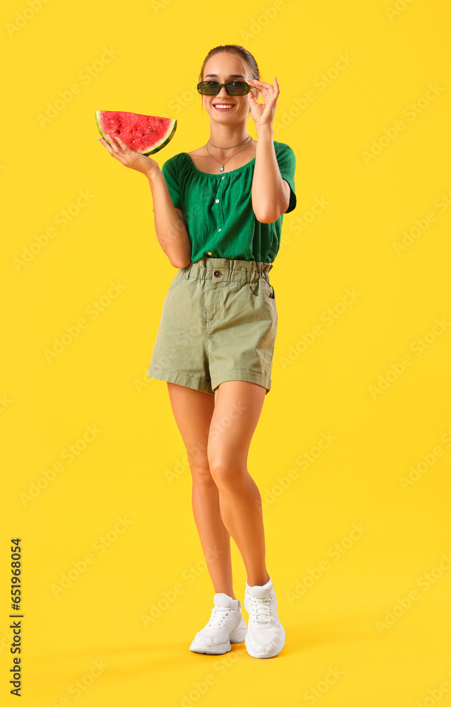 Young woman with fresh watermelon on yellow background