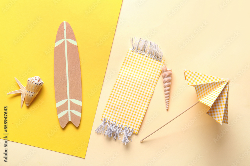 Creative summer composition with mini surfboard, umbrella and beach blanket on color background