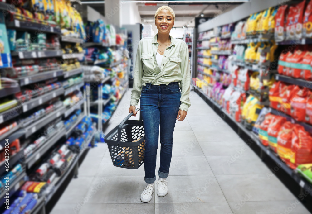 Portrait, basket and happy woman grocery shopping in retail, supermarket and convenience store for food. Groceries, market and African customer smile in shop for wholesale, sales deal and discount.