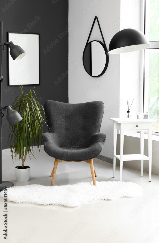 Interior of modern living room with black armchair and lamp