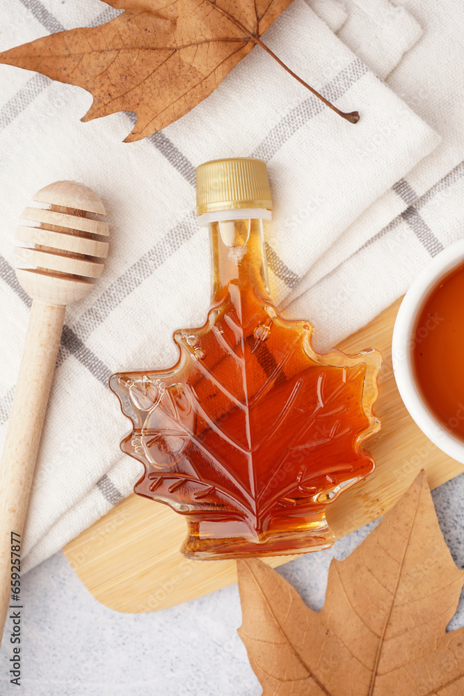 Bottle of tasty maple syrup on table