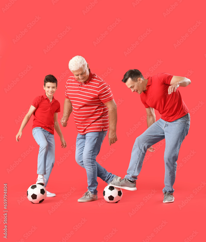 Little boy with his dad and grandfather playing football on red background