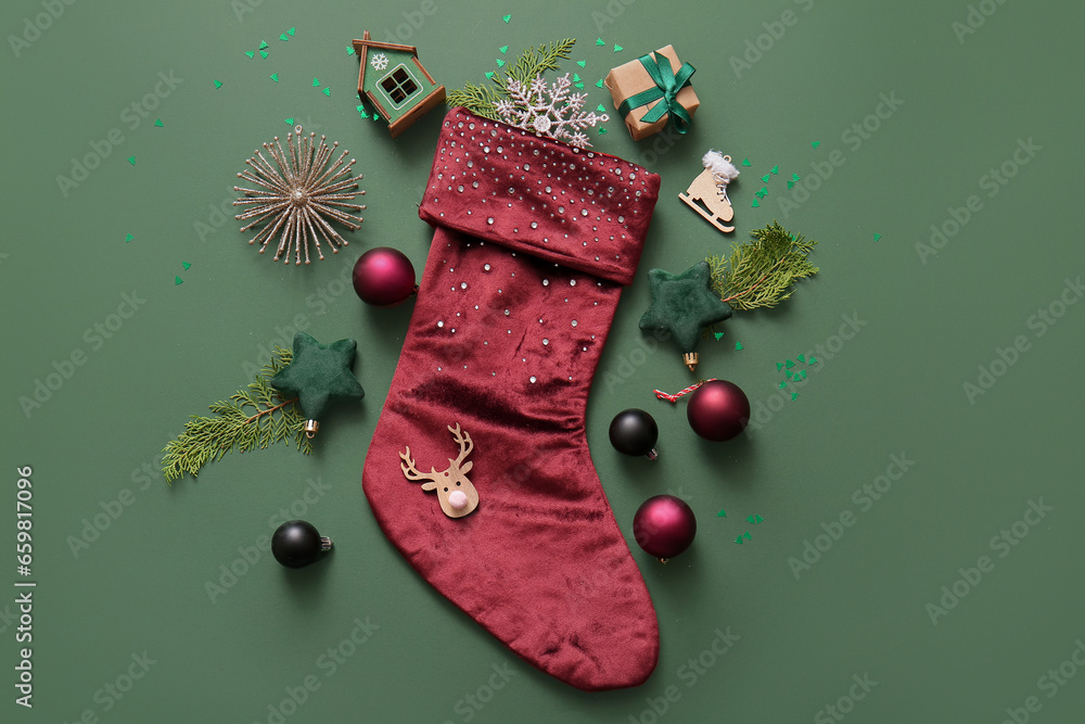 Beautiful Christmas sock with gift box and decorations on green background