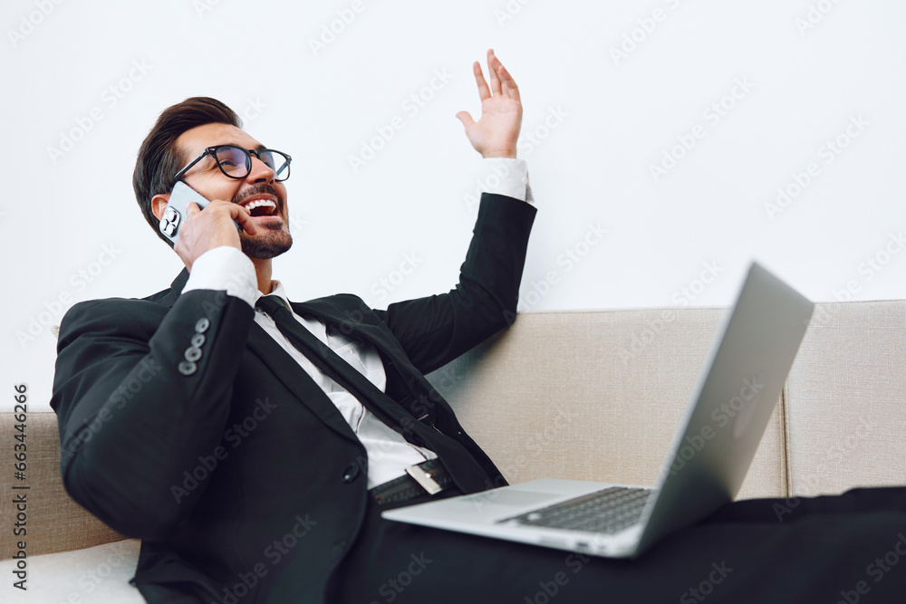 Man video computer suit phone couch office sitting talk call internet businessman winner smile laptop