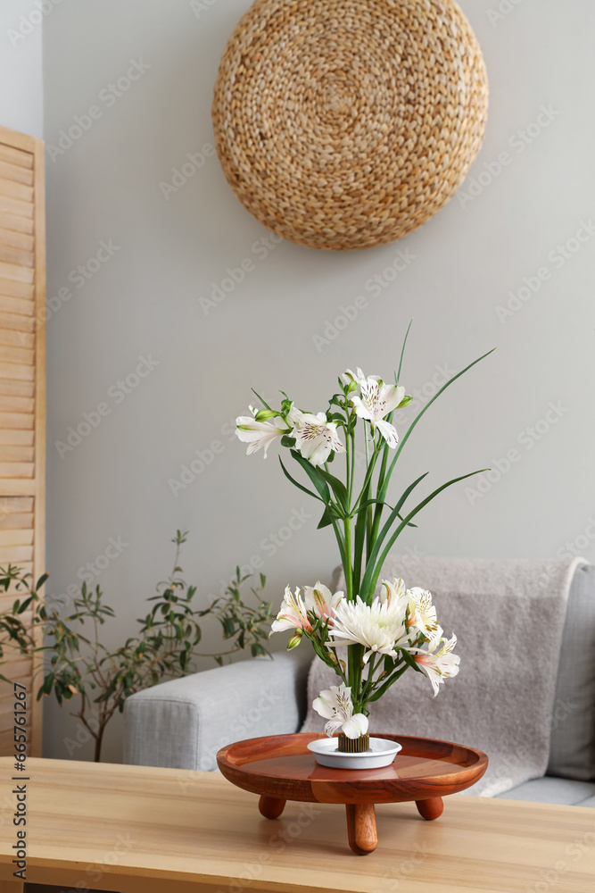 Beautiful ikebana on table in living room