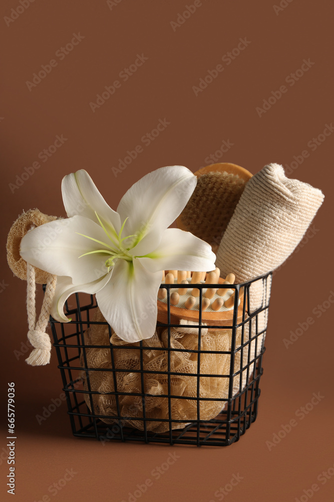 Basket with different spa accessories and beautiful lily flower on color background