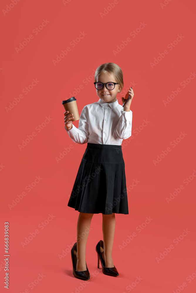 Cute little secretary girl with cup of coffee and mobile phone on red background