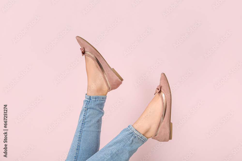 Female legs in stylish shoes on color background