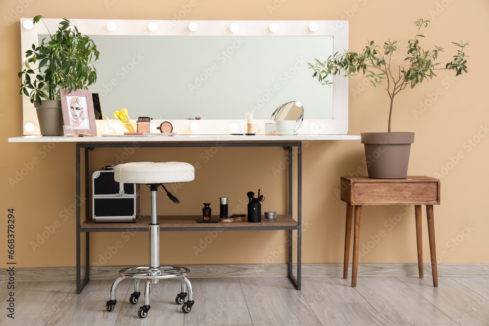 Dressing table with cosmetics and glowing mirror in makeup room