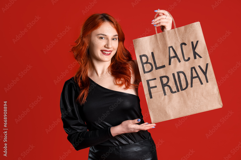 Beautiful woman with shopping bag on red background. Black Friday sale