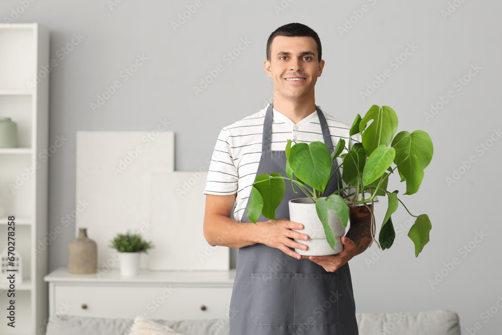 Male gardener with plant at home