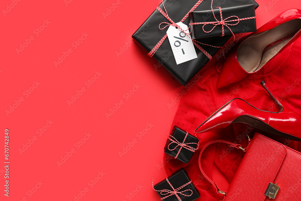 Composition with gift boxes, shoes and clothes on red background. Black Friday sale