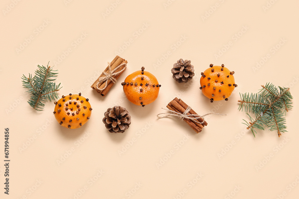Pomander balls with Christmas tree branches, cones and cinnamon on yellow background