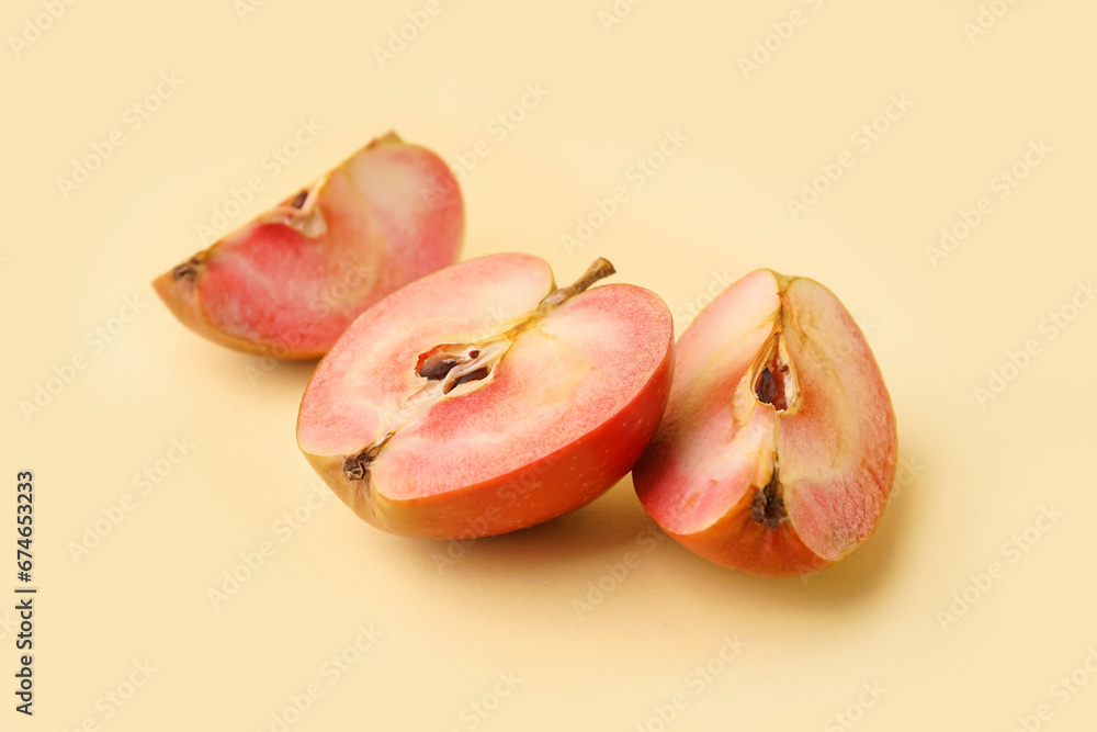 Cut pink apple on yellow background