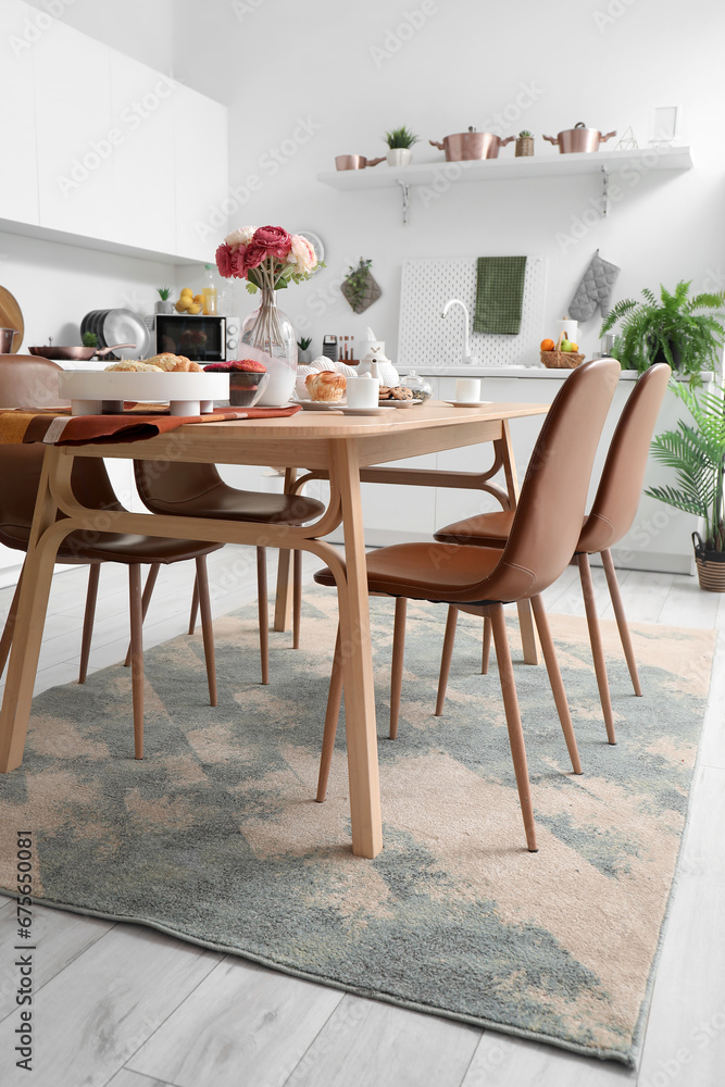 Served dining table on stylish carpet in modern kitchen