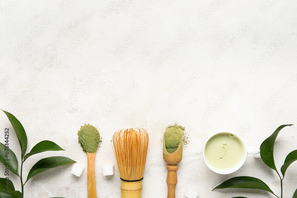 Composition with cup of fresh matcha tea, powder and plant branches on light background