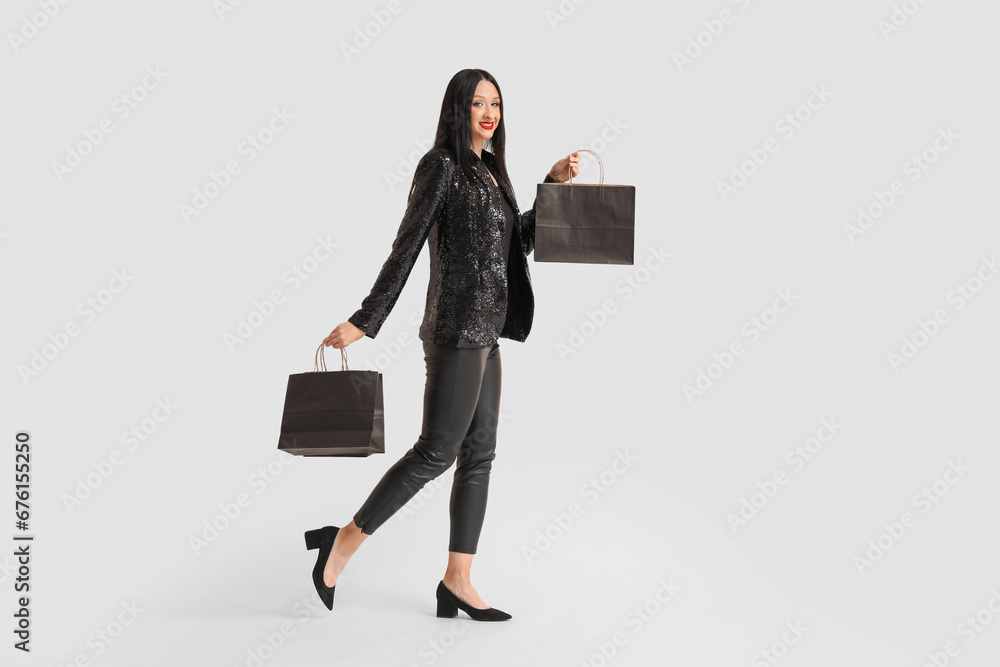 Beautiful stylish woman with shopping bags on white background. Black Friday Sale
