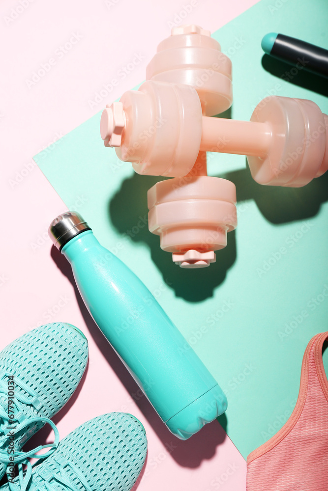 Bottle of water, dumbbells and shoes on color background