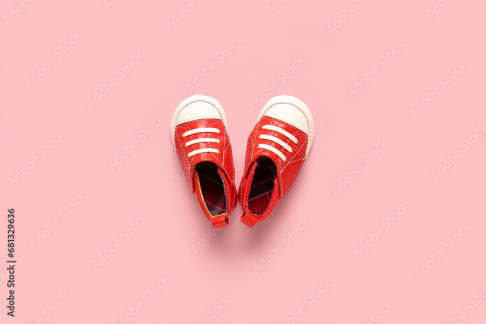 Stylish baby shoes on pink background