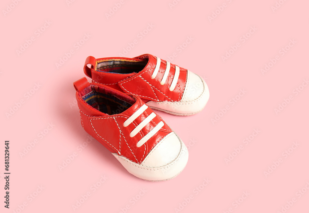 Stylish baby shoes on pink background