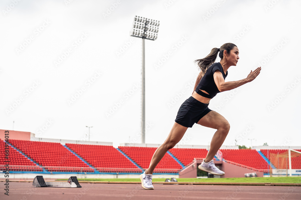 Asian young sportswoman sprint on a running track outdoors on stadium. 